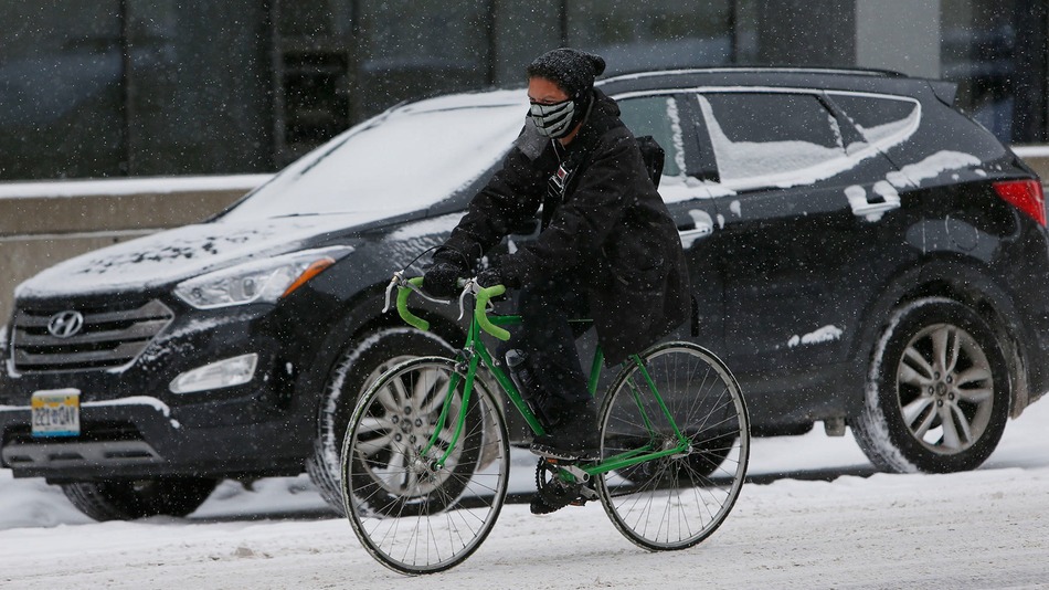A bicyclist is bundled up to deal with the elements while riding hrough downtown Denver, Wednesday, Nov. 12, 2014.